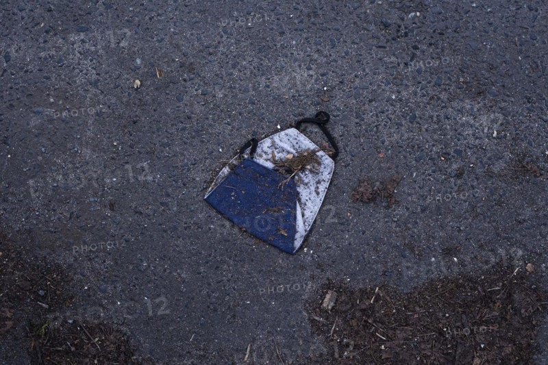 A discarded mouth-nose protection lies on the ground