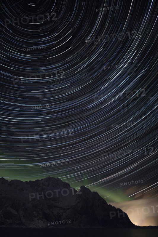 Star trails with some northern lights and rain clouds near Henningsvaer