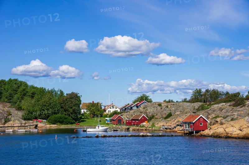 Picturesque rocky coast with small settlement and marina on an offshore island