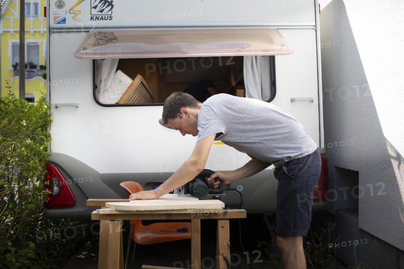 Man tinkering with his caravan.