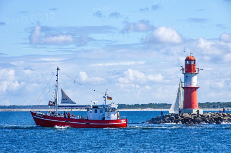 The fishing vessel PASEWALK leaves the harbour entrance with passengers and with a hoisted pirate flag towards the open sea