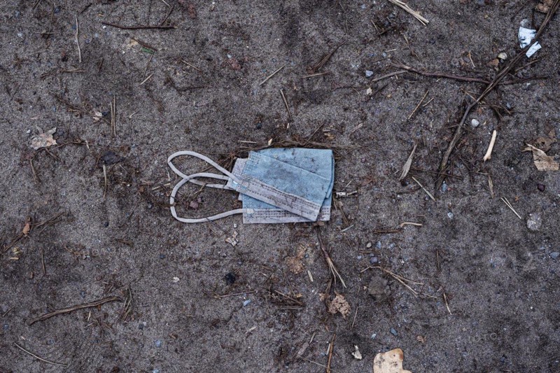 A discarded mouth-nose protection lies on the ground