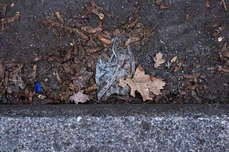 A discarded mouth-nose protection lies on the ground