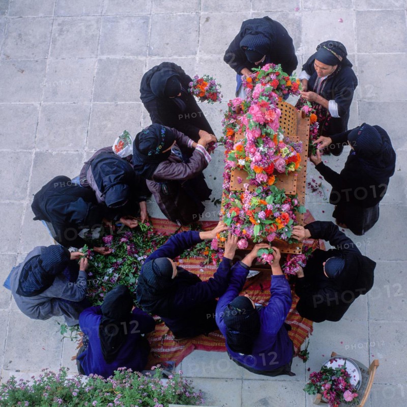 Women decorate an epitaph with flowers on Good Friday