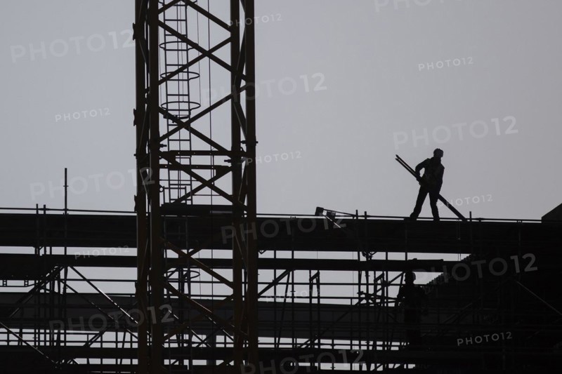 The silhouette of a scaffolder stands out on a construction site in Berlin