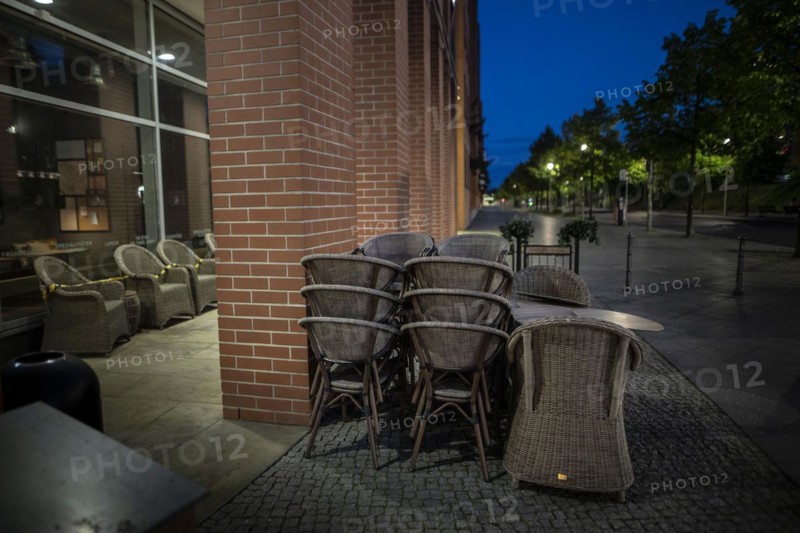 Unused furniture standing in front of a cafe at Potsdamer Platz in Berlin in the evening