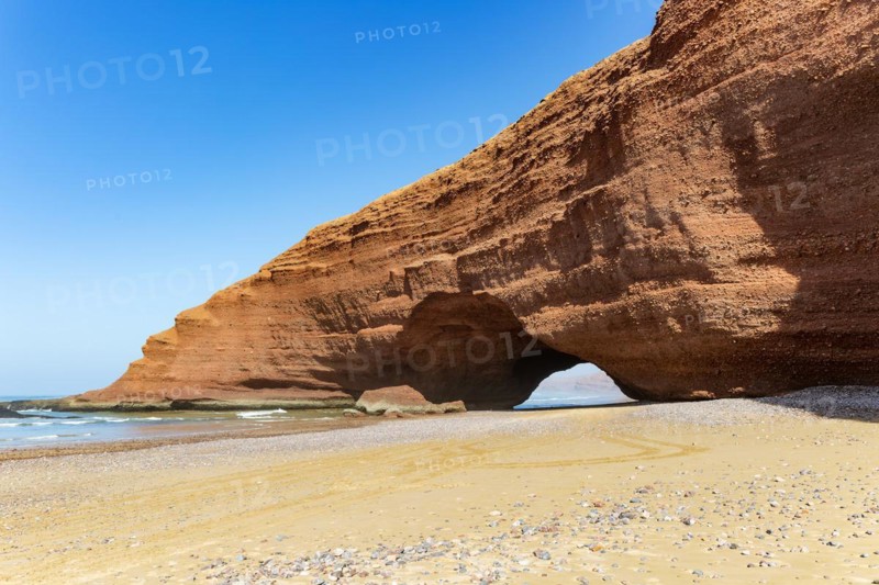 Natural rock coastal arch erosional landform on beach