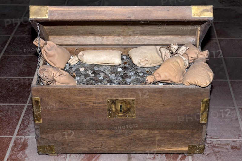 Wooden chest filled with coins and money bags