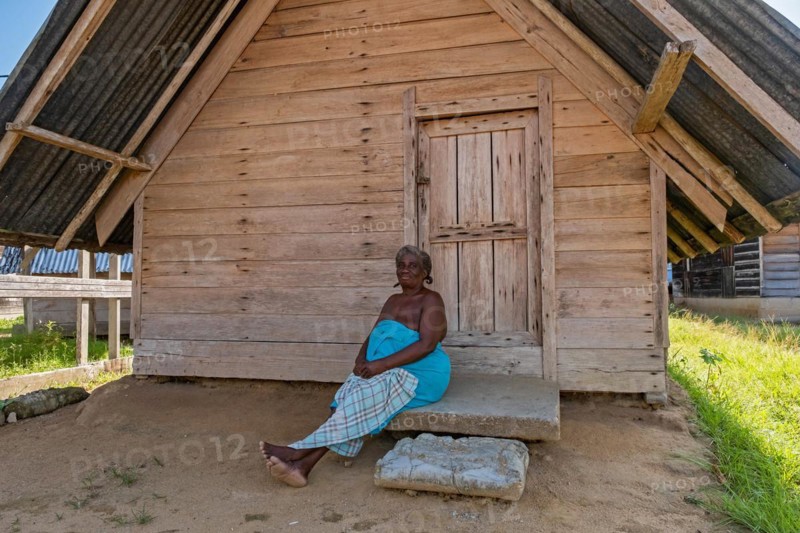 Afro-Surinamese woman posing in front of wooden house in the village Aurora