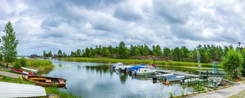 Small boats and picturesque shore landscape at the edge of Lake Vaenern in the area of Sunnana