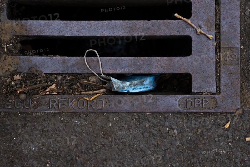 A discarded mouth-nose protection lies on the ground
