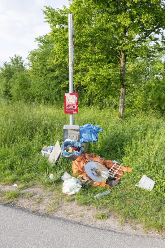 Destroyed rubbish bin with illegally deposited rubbish