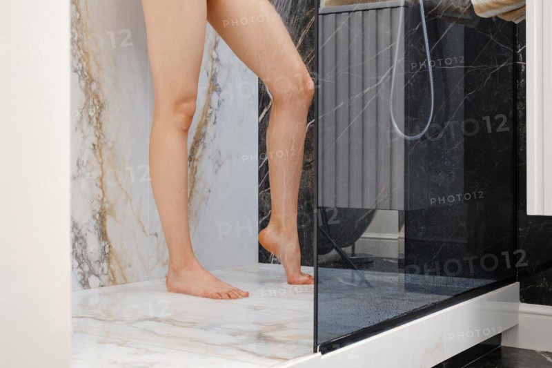 Unrecognizable woman washing her feet in shower cabin