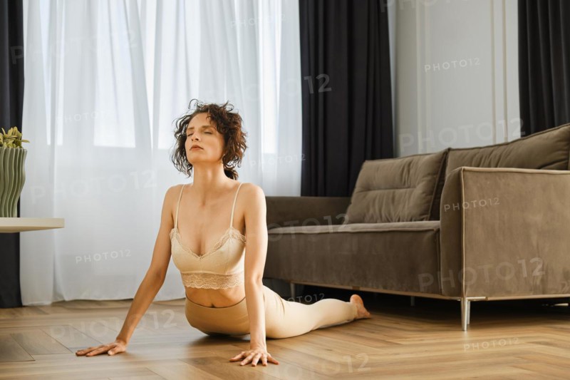 Woman doing yoga at home in cobra position