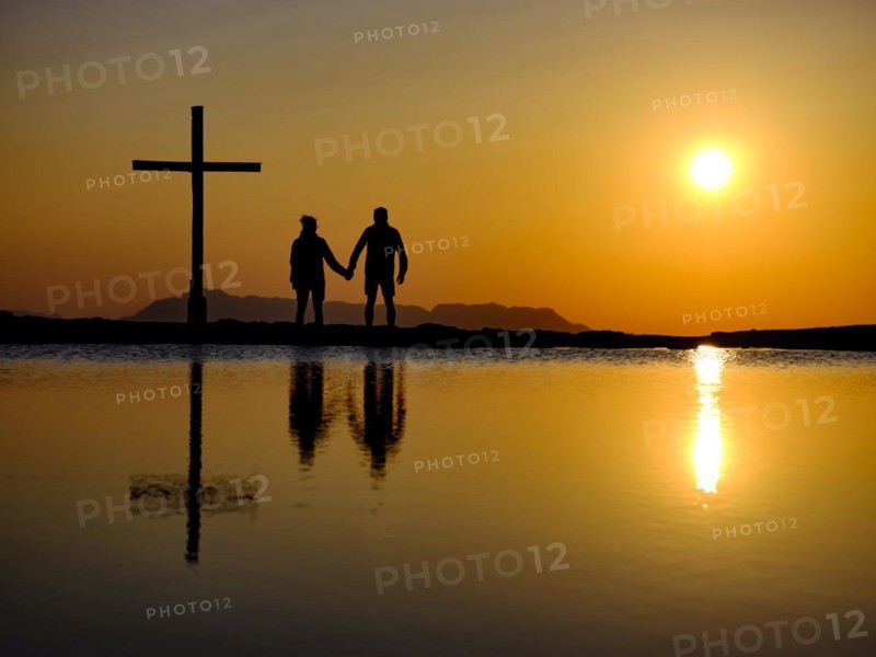 Couple next to summit cross at sunset