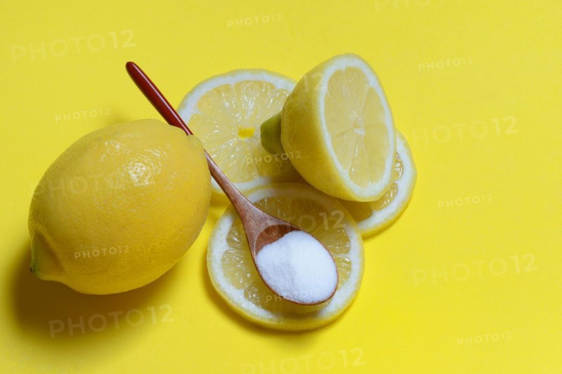 Citric acid in wooden spoon and lemon