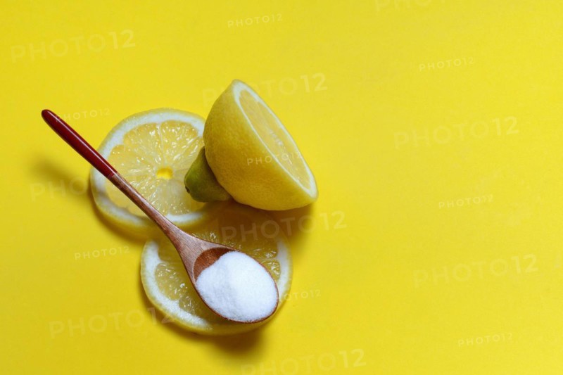 Citric acid in wooden spoon and lemon