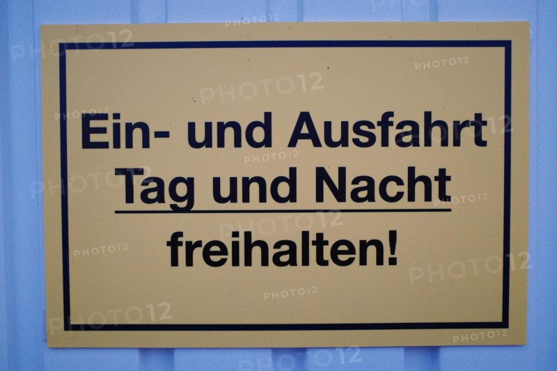 Sign with inscription Keep entrance and exit clear day and night!