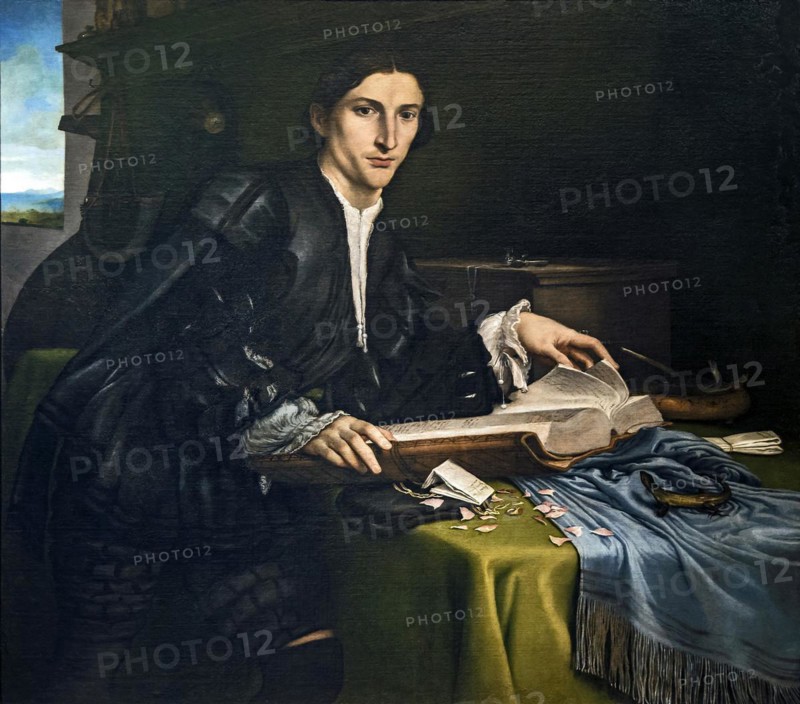 Portrait of a young man with a book in his study