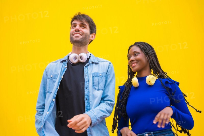 Multiethnic wedding couple of Caucasian man and woman of black ethnicity on a yellow background