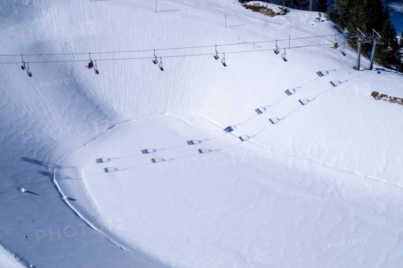 A chairlift casts its shadow over the reservoir in the Brauneck ski area