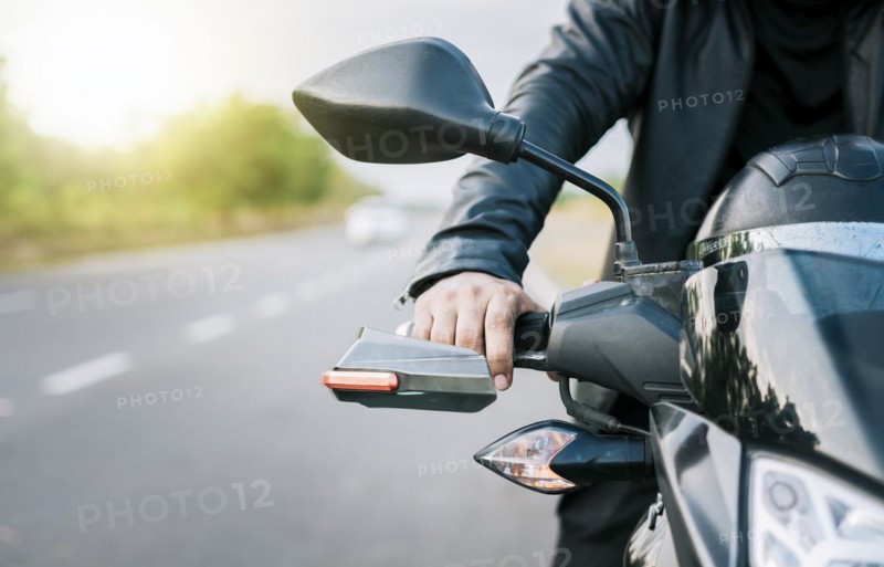 Close up of hands of biker on the handlebars of a motorcycle outdoors