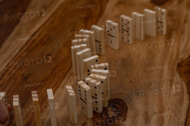 Wooden dominoes in a row on a wooden table