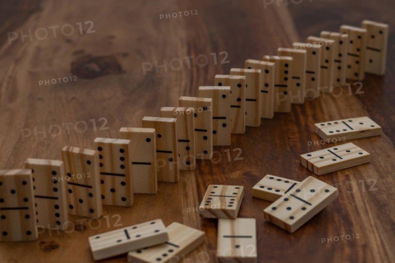 Wooden dominoes in a row on a wooden table