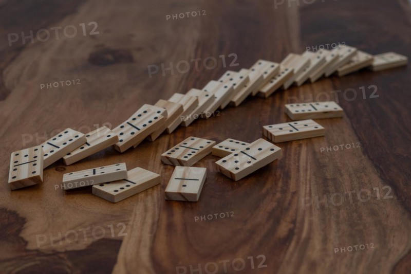 Wooden dominoes in a row on a wooden table