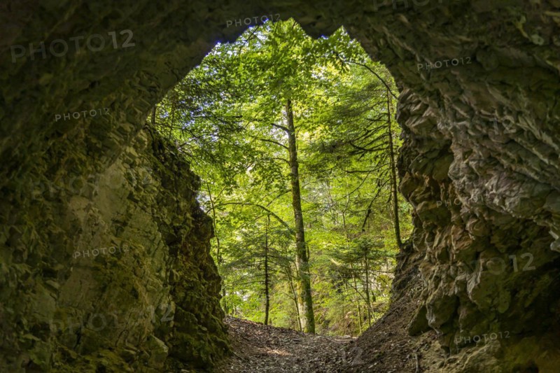 Tunnel in the rock on the hiking trail around the Lac des Moron reservoir between Switzerland and France