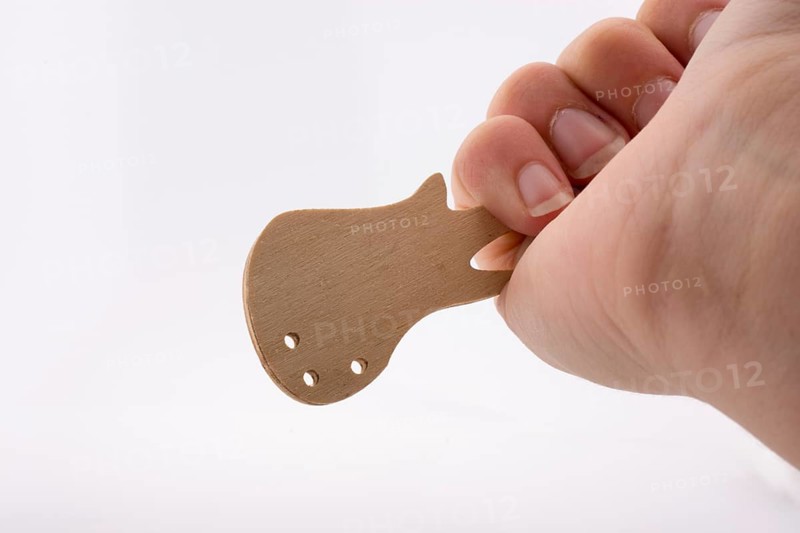 Mini wooden guitar model in hand on a white background