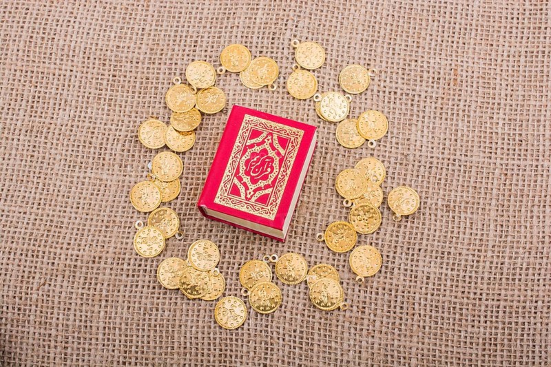 Fake gold coins around the Islamic Holy Book Quran
