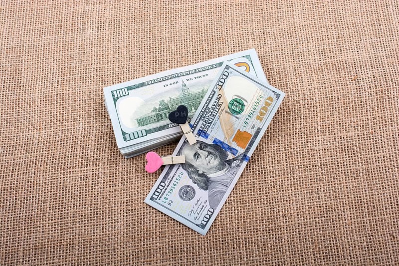 Heart icon bundle of US dollar placed on a linen canvas