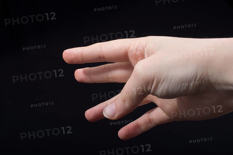 Five fingers of a child hand partly seen in black background