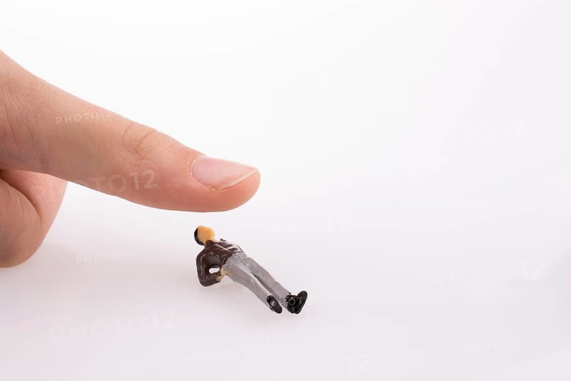 Hand threating to smash human figure on a white background