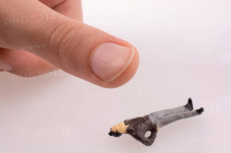 Hand threating to smash human figure on a white background