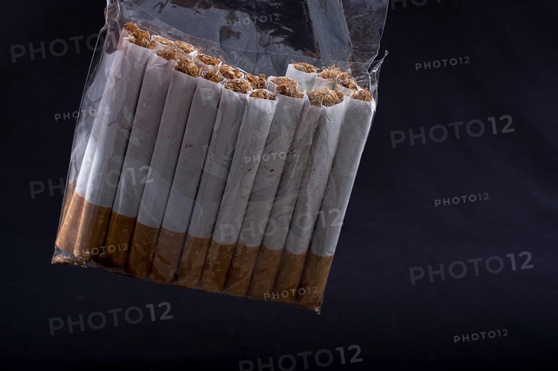 Pack of cigarette hanging on black background