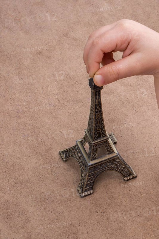 Child holding the little model of Eiffel Tower in hand