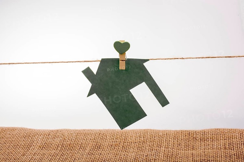 Little paper house attached to a string with a heart clip