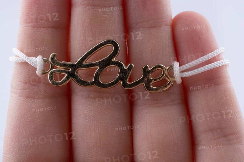 Love written with l letters made of metal in hand