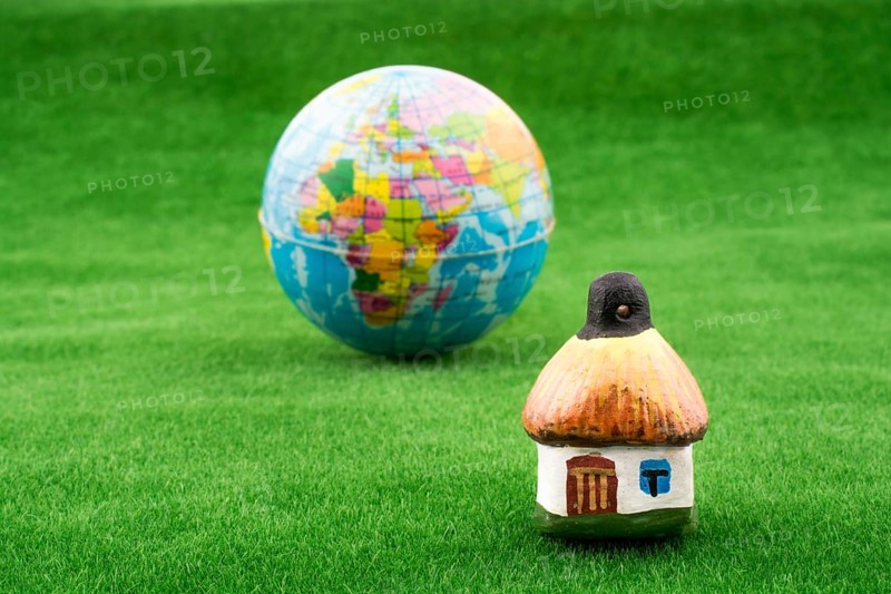 Hut near a globe on green grass