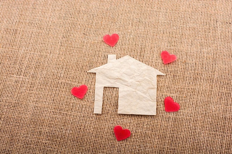 Heart shape around the paper house with a canvas background