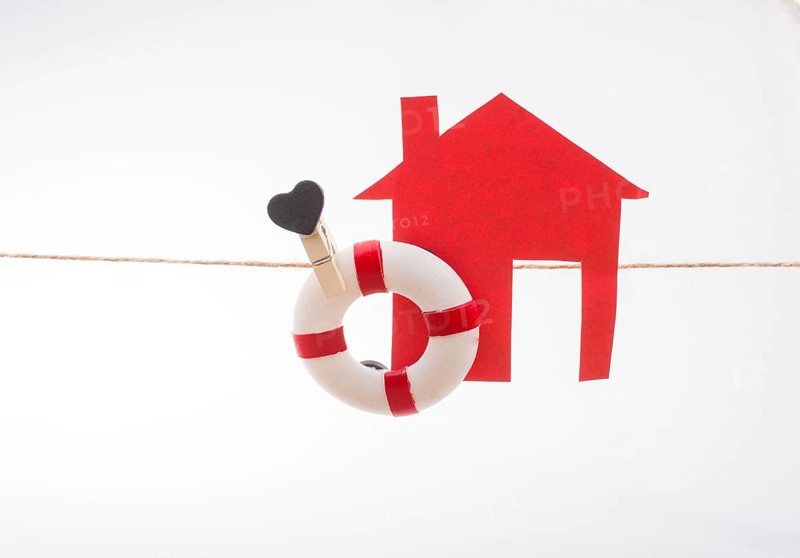 Model house and a life preserver with a heart on a string