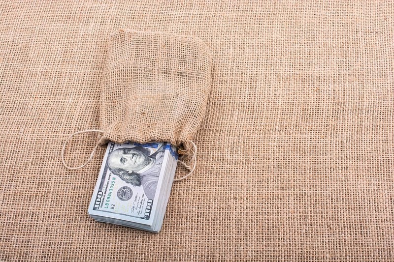 Banknote bundle of US dollarin a sack on a canvas