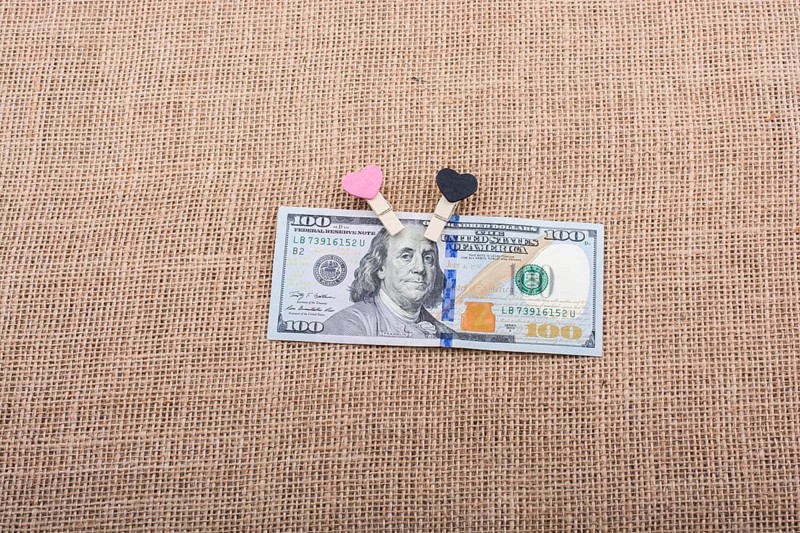 Heart icon bundle of US dollar placed on a linen canvas