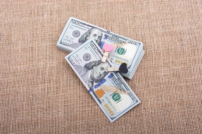 Heart icon bundle of US dollar placed on a linen canvas