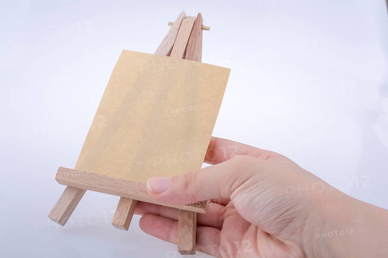 Brown color notepaper on a painting tripod in hand