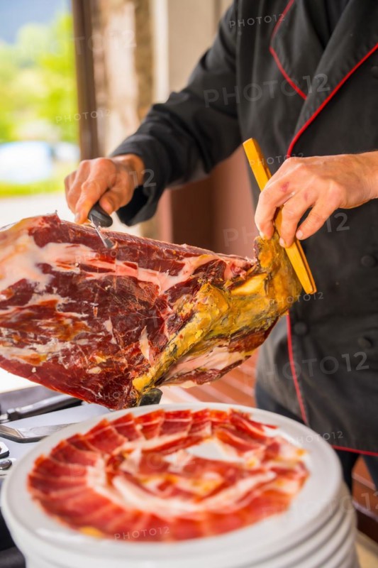 Detail of a man cutting Iberian ham at a wedding