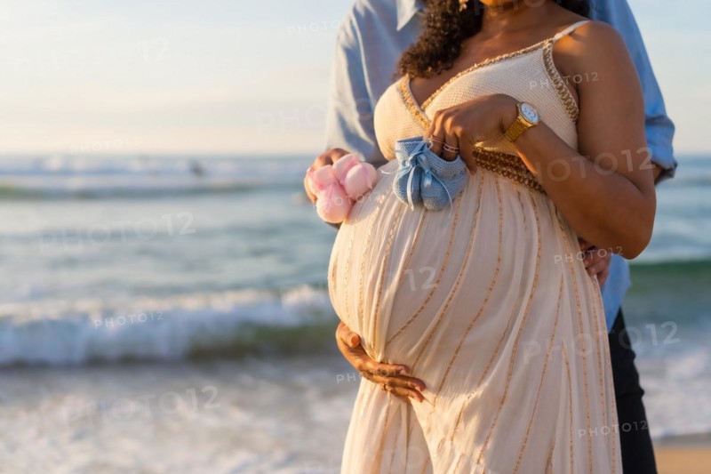 Pregnant maternity latin woman on the beach at sunset