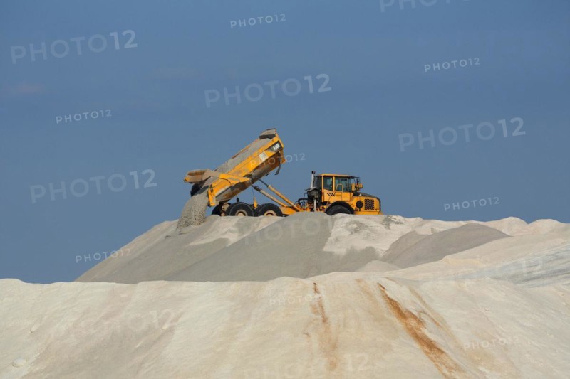 Dump truck unloading salt at a salt mine for salt extraction